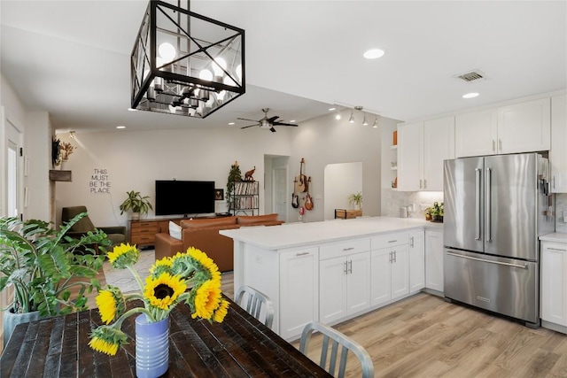7619 Scenic Brook Dr, Austin, TX 78736 - kitchen with high end refrigerator, a peninsula, light countertops, white cabinets, and light wood-style flooring