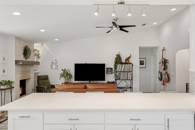 7619 Scenic Brook Dr, Austin, TX 78736 - kitchen with vaulted ceiling, a fireplace, ceiling fan, open floor plan, and white cabinets