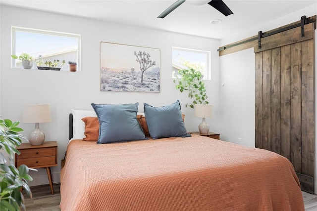 7619 Scenic Brook Dr, Austin, TX 78736 - bedroom with wood finished floors, a barn door, and a ceiling fan