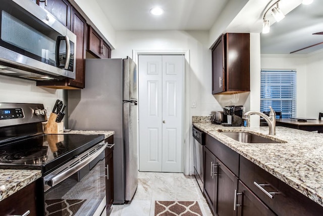 501 W 26th St Unit 105, Austin, TX 78705 - kitchen featuring appliances with stainless steel finishes, dark brown cabinets, light stone counters, light marble finish floors, and recessed lighting