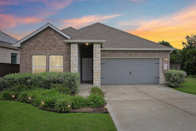 1524 Brueggerhoff Rd, Leander, TX 78641 - view of front of house with an attached garage, brick siding, driveway, and roof with shingles