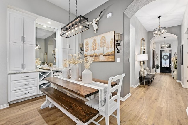 169 Fort Cobb Way, Georgetown, TX 78628 - dining room featuring arched walkways, a chandelier, light wood-style flooring, and recessed lighting