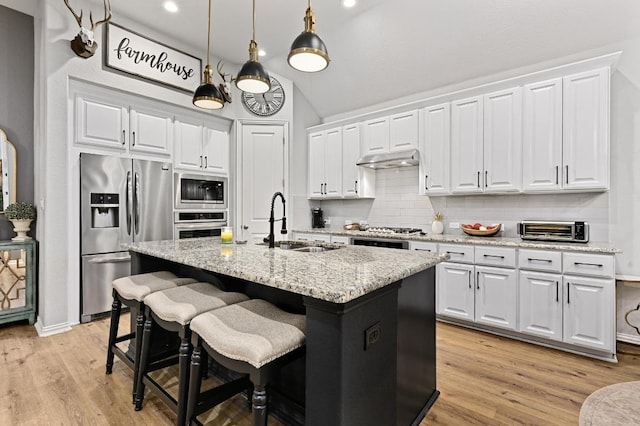 169 Fort Cobb Way, Georgetown, TX 78628 - kitchen featuring appliances with stainless steel finishes, decorative backsplash, white cabinetry, light wood-type flooring, and vaulted ceiling