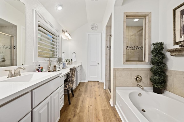 169 Fort Cobb Way, Georgetown, TX 78628 - bathroom with a shower stall, vanity, a bath, vaulted ceiling, and wood finished floors