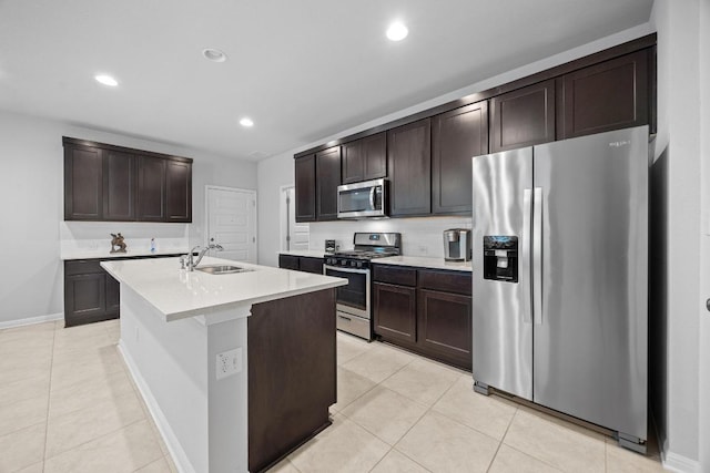 2424 Pecan Island Dr, Leander, TX 78641 - kitchen with stainless steel appliances, light countertops, light tile patterned floors, dark brown cabinets, and recessed lighting