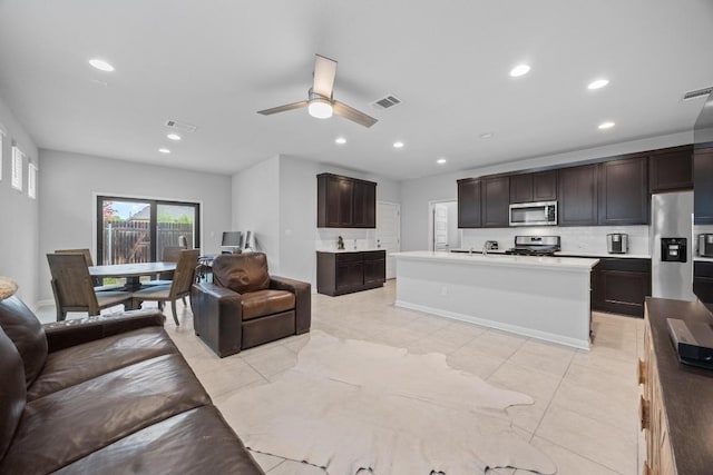 2424 Pecan Island Dr, Leander, TX 78641 - kitchen featuring open floor plan, stainless steel appliances, light tile patterned floors, tasteful backsplash, and recessed lighting