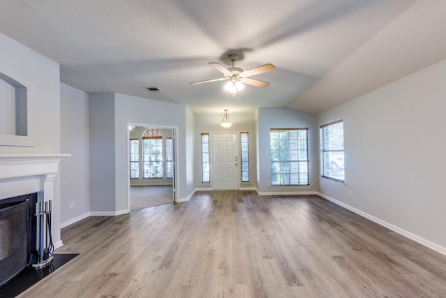 15737 Cadoz Dr, Austin, TX 78728 - unfurnished living room featuring wood finished floors, a fireplace with flush hearth, ceiling fan, and vaulted ceiling