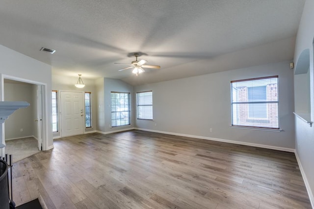 15737 Cadoz Dr, Austin, TX 78728 - unfurnished living room featuring a ceiling fan, wood finished floors, lofted ceiling, and a textured ceiling