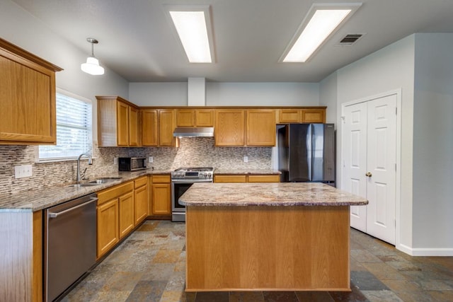 15737 Cadoz Dr, Austin, TX 78728 - kitchen with appliances with stainless steel finishes, under cabinet range hood, stone tile floors, and a kitchen island