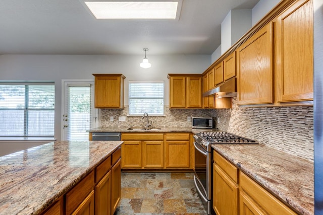 15737 Cadoz Dr, Austin, TX 78728 - kitchen with stainless steel appliances, under cabinet range hood, stone finish flooring, backsplash, and light stone counters