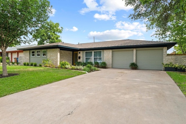 1909 Belford Dr, Austin, TX 78757 - view of front facade featuring a garage, stone siding, a front yard, and driveway