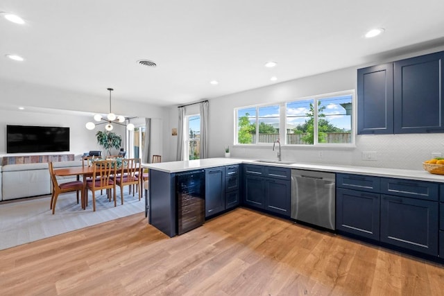 1909 Belford Dr, Austin, TX 78757 - kitchen with stainless steel dishwasher, beverage cooler, light countertops, light wood-style floors, and a peninsula