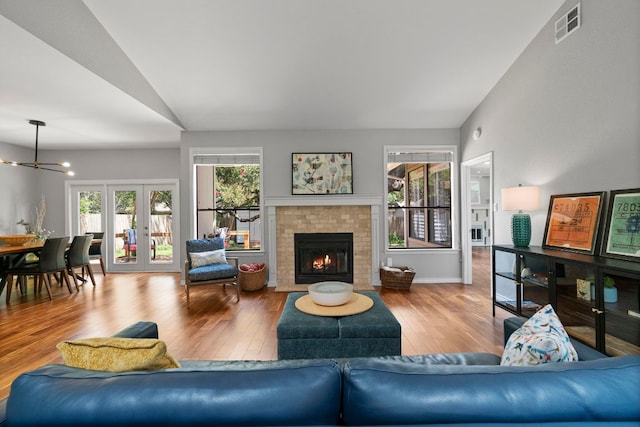 5812 Abilene Trl, Austin, TX 78749 - living room featuring lofted ceiling, a chandelier, wood finished floors, and a brick fireplace