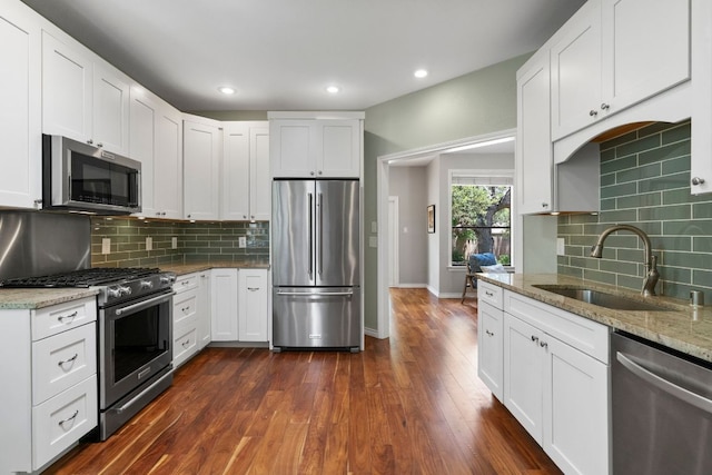 5812 Abilene Trl, Austin, TX 78749 - kitchen featuring stainless steel appliances, decorative backsplash, light stone countertops, dark wood-style floors, and recessed lighting