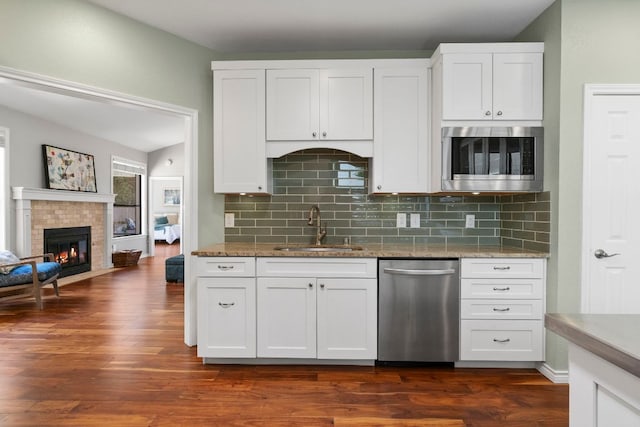 5812 Abilene Trl, Austin, TX 78749 - kitchen with stainless steel dishwasher, built in microwave, backsplash, and light stone counters