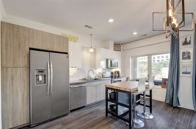 4361 S Congress Ave Unit 126, Austin, TX 78745 - kitchen with appliances with stainless steel finishes, dark wood-style flooring, tasteful backsplash, recessed lighting, and decorative light fixtures