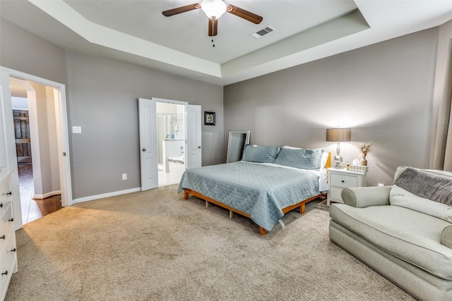 544 Blossom Valley Strm, Buda, TX 78610 - bedroom featuring carpet floors, a raised ceiling, ensuite bathroom, and a ceiling fan