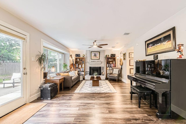 7702 Kincheon Ct, Austin, TX 78749 - living room featuring wood finished floors, a ceiling fan, and a fireplace