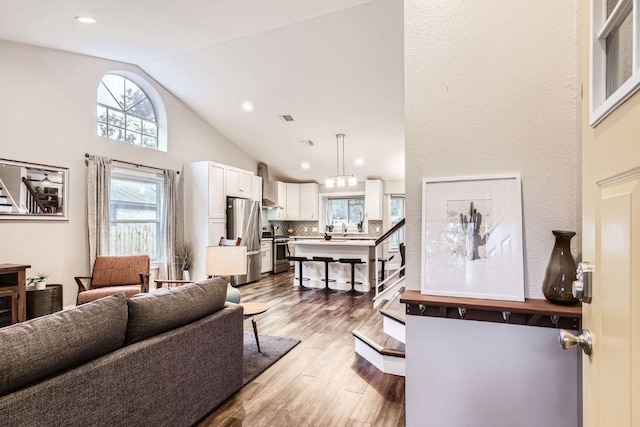 7702 Kincheon Ct, Austin, TX 78749 - living room featuring stairs, wood finished floors, recessed lighting, and high vaulted ceiling