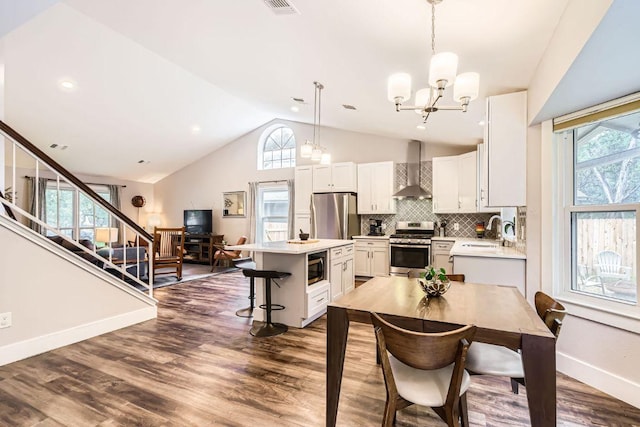 7702 Kincheon Ct, Austin, TX 78749 - dining area with vaulted ceiling, a chandelier, dark wood-type flooring, and stairway