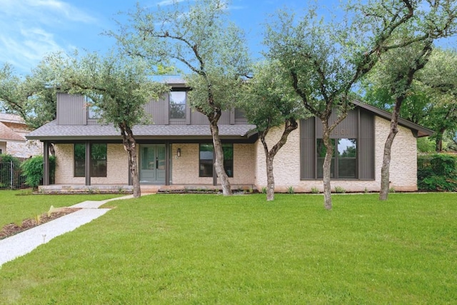 10501 Ronwood Dr, Austin, TX 78750 - mid-century modern home featuring covered porch, a front lawn, and a shingled roof