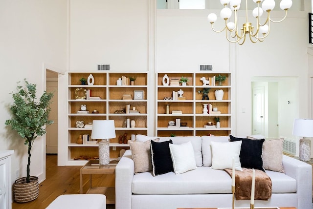 10501 Ronwood Dr, Austin, TX 78750 - living room featuring wood finished floors, a high ceiling, and a chandelier