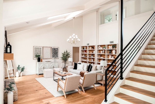 10501 Ronwood Dr, Austin, TX 78750 - living room featuring beamed ceiling, stairway, a chandelier, light wood finished floors, and high vaulted ceiling