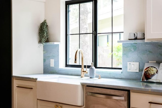 10501 Ronwood Dr, Austin, TX 78750 - kitchen with stainless steel dishwasher, white cabinetry, and light countertops