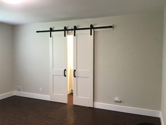 11303 Toledo Dr, Austin, TX 78759 - unfurnished room with dark wood-type flooring and a barn door