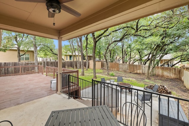 240 Fort Mabry Loop, Georgetown, TX 78628 - fenced backyard with an outdoor fire pit, a deck, a ceiling fan, a storage unit, and a patio