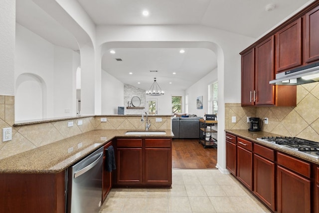 240 Fort Mabry Loop, Georgetown, TX 78628 - kitchen featuring dark brown cabinets, stainless steel appliances, arched walkways, light stone countertops, and under cabinet range hood