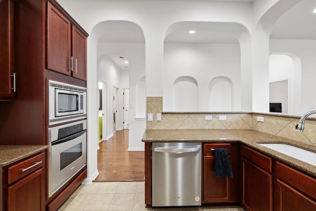 240 Fort Mabry Loop, Georgetown, TX 78628 - kitchen with appliances with stainless steel finishes, dark brown cabinets, stone countertops, and recessed lighting