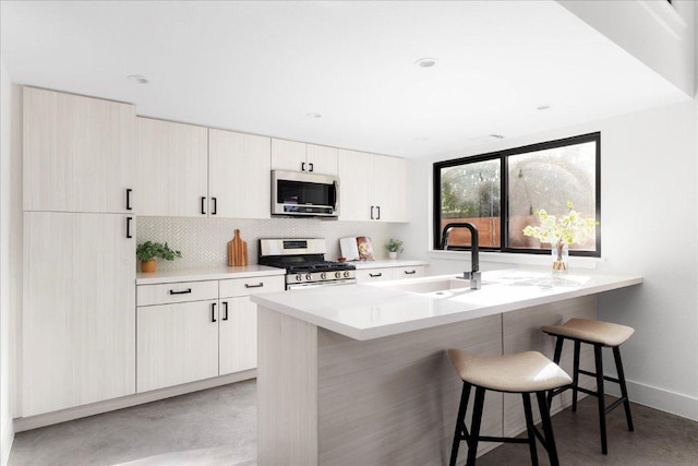409 W 55th 1/2 St Unit 2, Austin, TX 78751 - kitchen with stainless steel appliances, a kitchen bar, backsplash, light countertops, and a peninsula