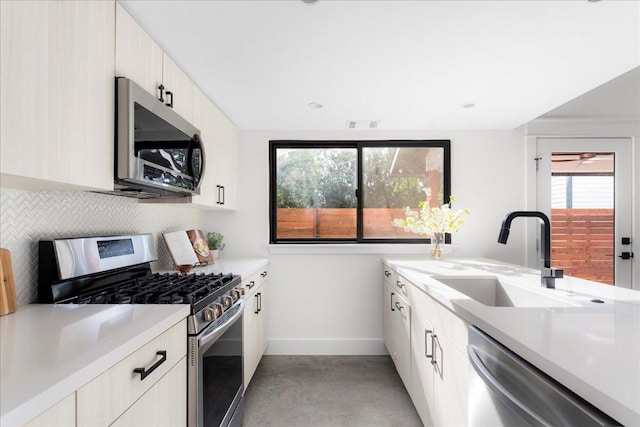 409 W 55th 1/2 St Unit 2, Austin, TX 78751 - kitchen with appliances with stainless steel finishes, concrete floors, light countertops, decorative backsplash, and modern cabinets
