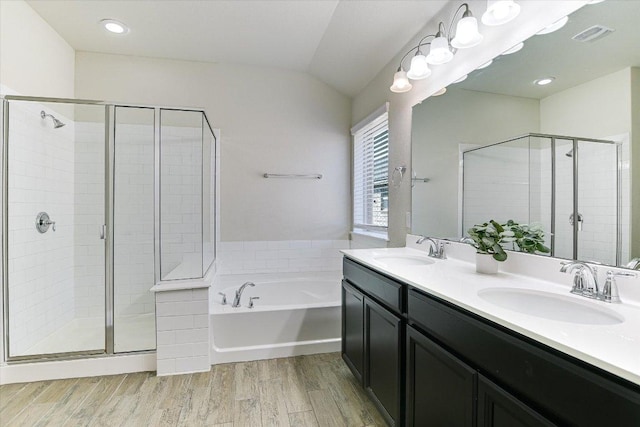 18211 Winnow Way, Pflugerville, TX 78660 - bathroom featuring a garden tub, double vanity, a shower stall, wood finished floors, and vaulted ceiling