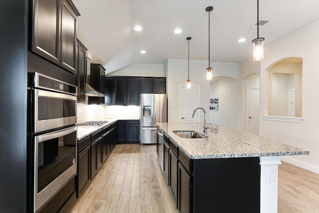 18211 Winnow Way, Pflugerville, TX 78660 - kitchen featuring stainless steel appliances, light wood-style flooring, light stone countertops, tasteful backsplash, and recessed lighting