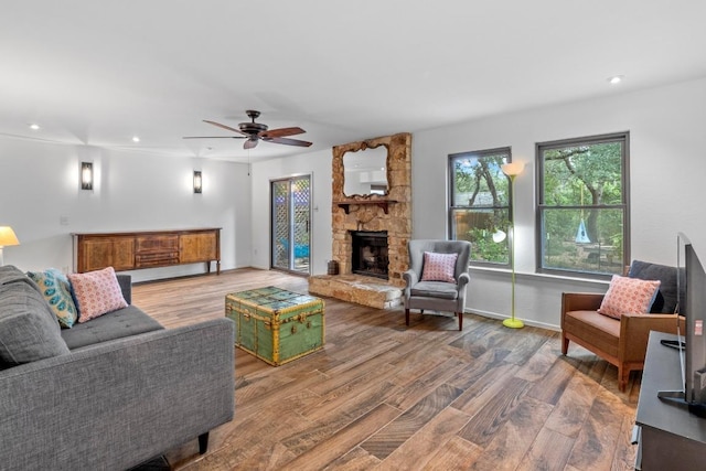 4304 Adelphi Ln, Austin, TX 78727 - living room featuring wood finished floors, a stone fireplace, a ceiling fan, and recessed lighting