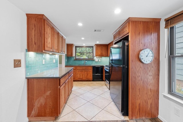 4304 Adelphi Ln, Austin, TX 78727 - kitchen with black appliances, decorative backsplash, brown cabinetry, recessed lighting, and light tile patterned floors