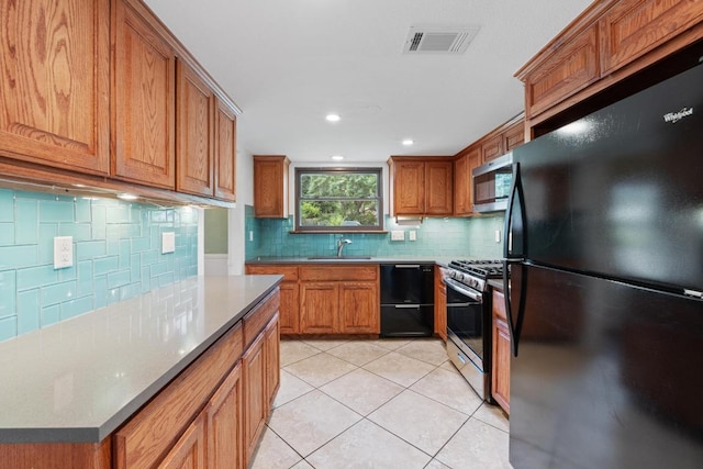 4304 Adelphi Ln, Austin, TX 78727 - kitchen featuring black appliances, decorative backsplash, brown cabinetry, light tile patterned flooring, and recessed lighting