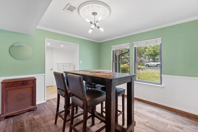 4304 Adelphi Ln, Austin, TX 78727 - dining area with wood finished floors, a chandelier, ornamental molding, and wainscoting