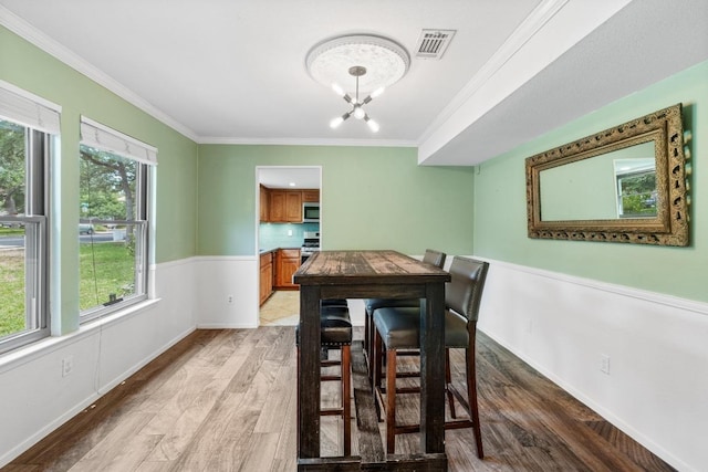 4304 Adelphi Ln, Austin, TX 78727 - dining area with ornamental molding, light wood finished floors, and a chandelier