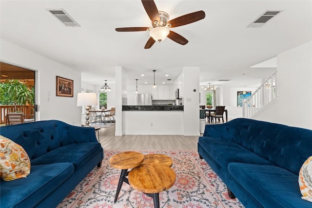 4410 Cisco Valley Dr, Round Rock, TX 78664 - living room with a chandelier, light wood-style flooring, plenty of natural light, and a ceiling fan