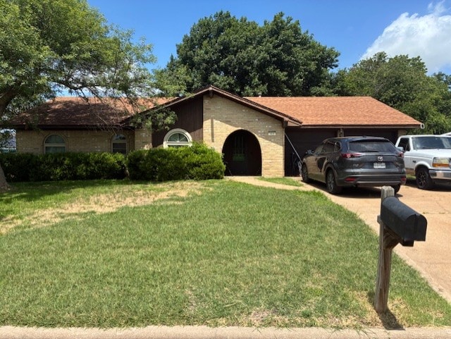 410 Phoenix Dr, Temple, TX 76504 - ranch-style house with concrete driveway, a front lawn, an attached garage, and brick siding