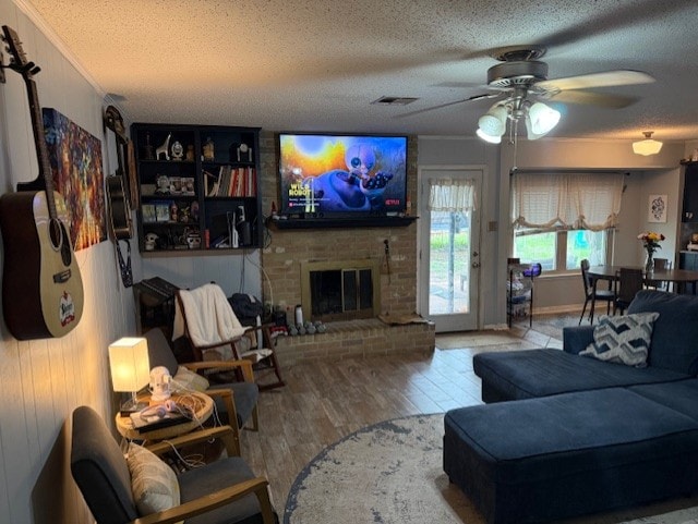 410 Phoenix Dr, Temple, TX 76504 - living area with a textured ceiling, ceiling fan, wood finished floors, and a brick fireplace