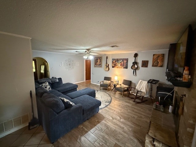 410 Phoenix Dr, Temple, TX 76504 - living area featuring arched walkways, ceiling fan, wood finished floors, and a textured ceiling