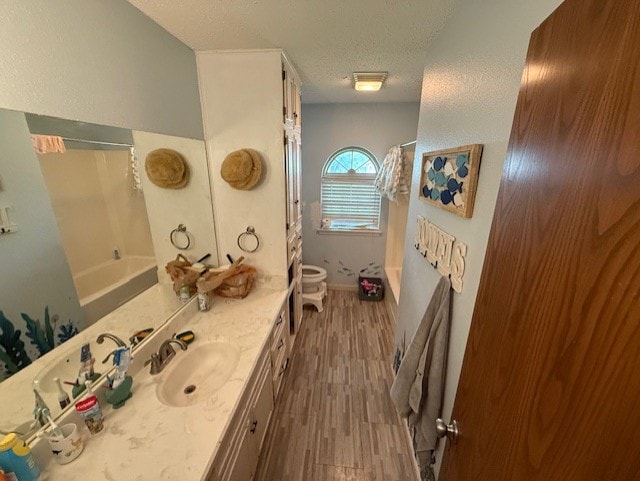 410 Phoenix Dr, Temple, TX 76504 - full bathroom with wood finished floors, vanity, a textured ceiling, and shower / bath combination with curtain