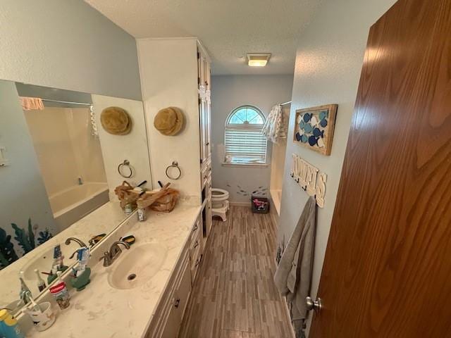 410 Phoenix Dr, Temple, TX 76504 - full bathroom featuring vanity, wood finished floors, shower / bath combo, and a textured ceiling