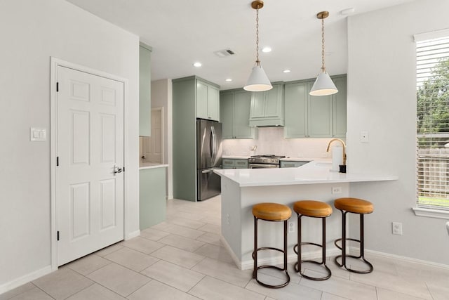 5701 Sunset Rdg, Austin, TX 78735 - kitchen with green cabinets, appliances with stainless steel finishes, backsplash, a peninsula, and a kitchen bar