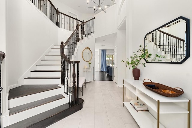 5701 Sunset Rdg, Austin, TX 78735 - stairs featuring a high ceiling, tile patterned floors, and a chandelier