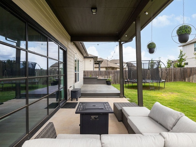 453 Arrowhead Vine St, Leander, TX 78641 - fenced backyard featuring a trampoline, an outdoor living space with a fire pit, a patio area, and a deck